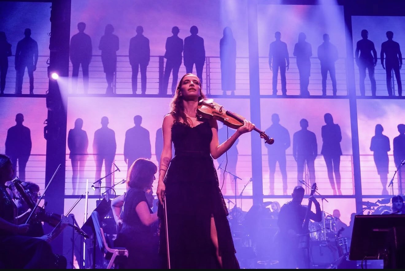 Berfin Aksu performing as soloist in front of a symphony orchestra